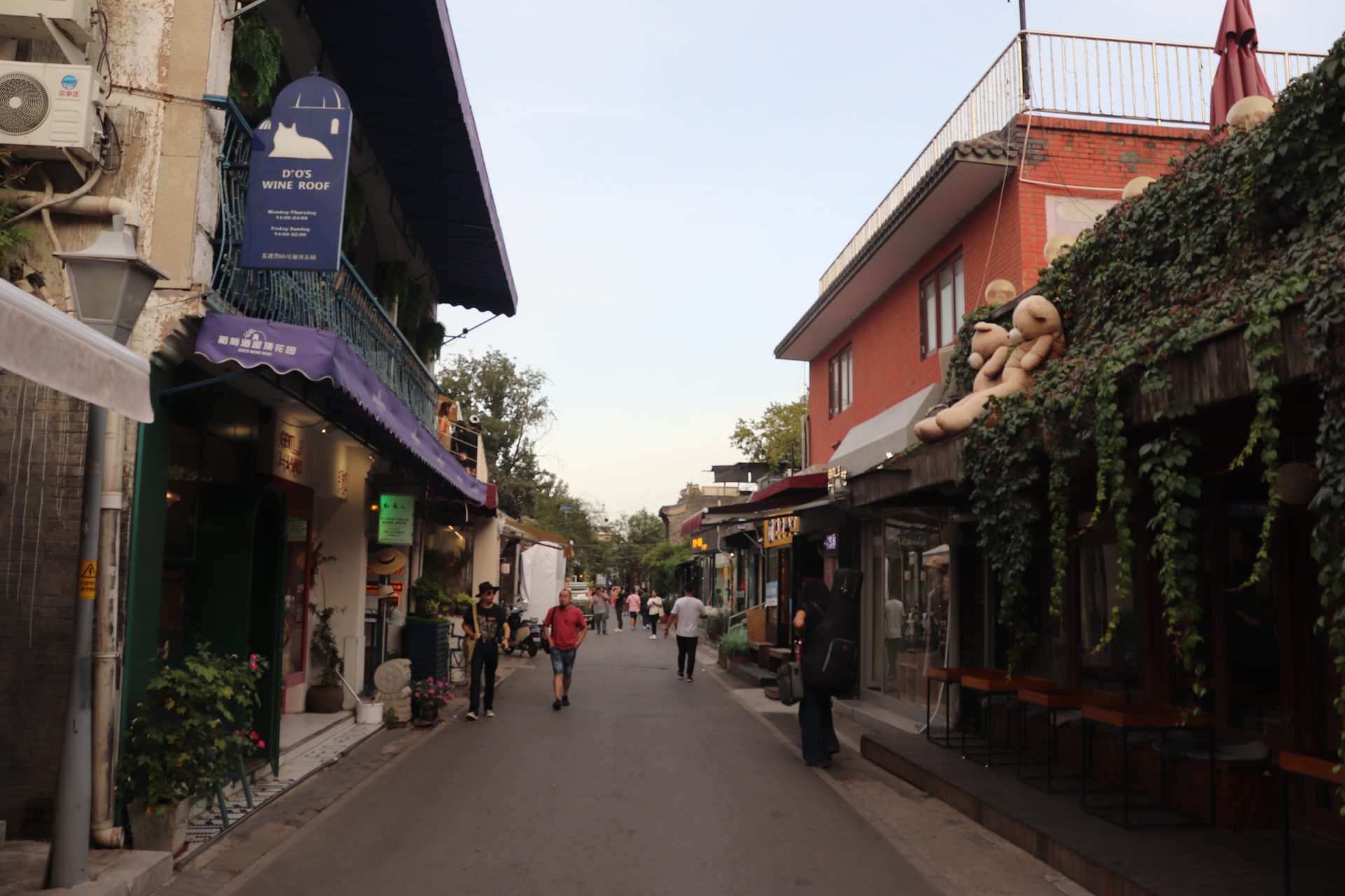 A Beijing hutong lane in the evening lined with small bars and shops, Wudaoying — Photo: Andrzej Otrębski / CC BY-SA 4.0 via Wikimedia Commons