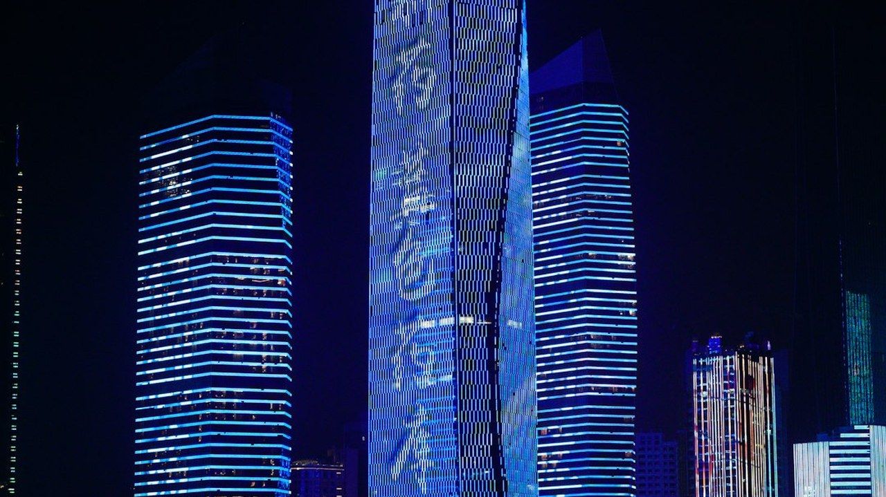 Qingdao's CBD towers lit up after dark — the last fast train from the airport reaches May Fourth Square at 23:54