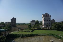 Three diaolou towers standing over farmland in Zili village, Kaiping — Photo: DragonSamYU / CC BY-SA 4.0 via Wikimedia Commons